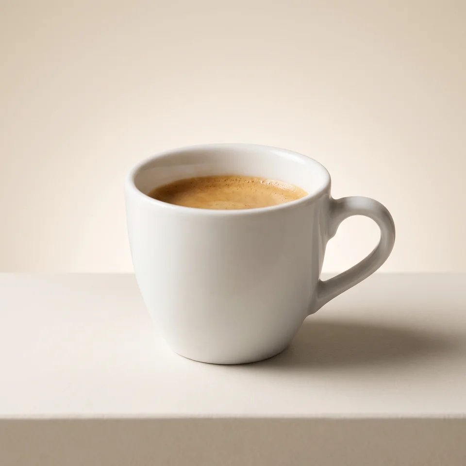 Espresso with crema in a small light-coloured cup.