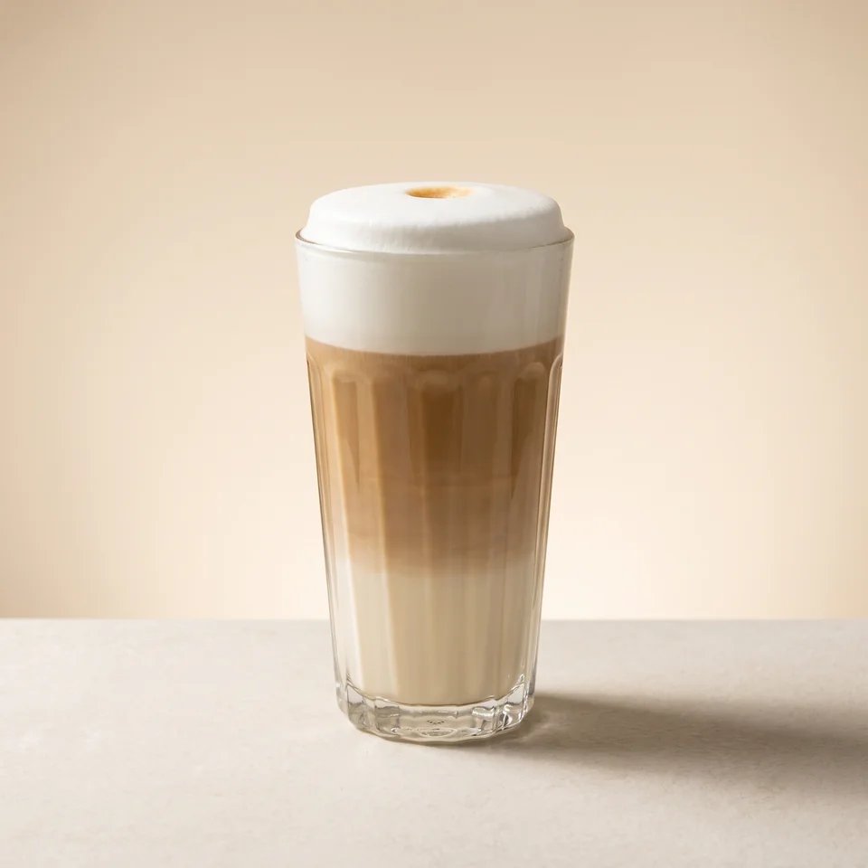 Flavoured Latte with a light milk-foam topping in a fluted glass.